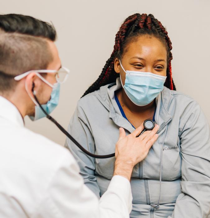 Caregiver checking patient's heart at medical facility